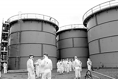 3月1日，一群日本記者在福島第一核電站內(nèi)的污水儲藏罐前采訪。日益增多的核污水是當前事故搶修工作面臨的主要難題之一。資料圖片