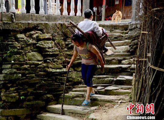 圖為趙先瓊背著婆婆出村就醫(yī)（資料圖）。
