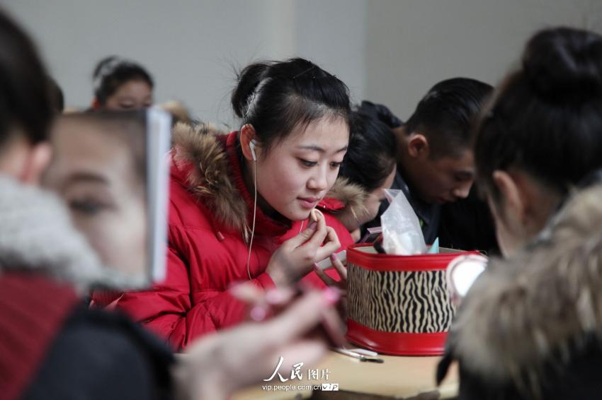 2014年2月17日，山東濱州，藝考候考考生在濱州學院報名點化妝。