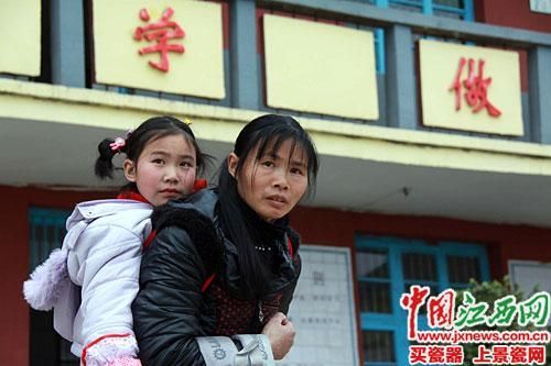 蘭愛紅背著女兒放學(xué)。